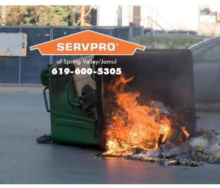 green dumpster with a fire