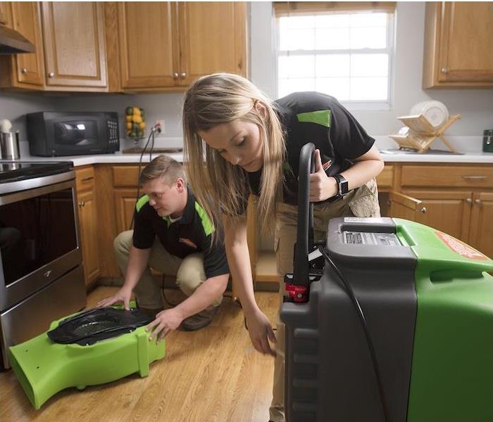 a SERVPRO crew setting up machines to clean a kitchen
